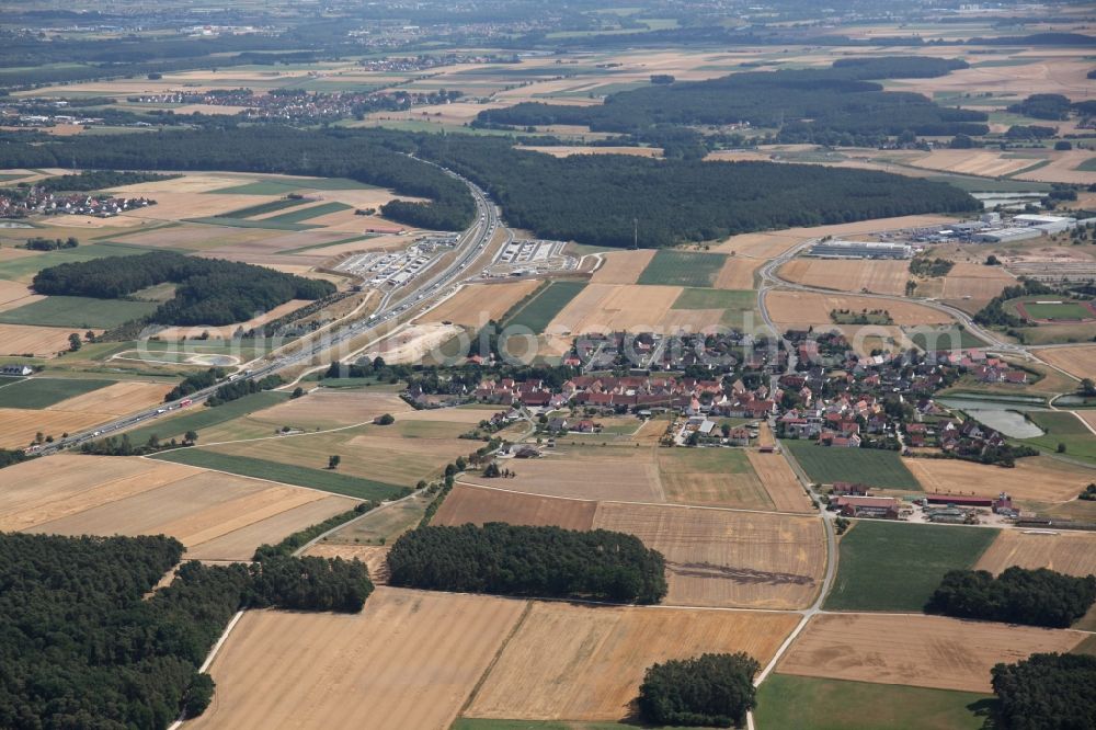 Herzogenaurach from the bird's eye view: Structures on agricultural fields in Herzogenaurach in the state Bavaria. In the background the A3 motorway with a motorway service area