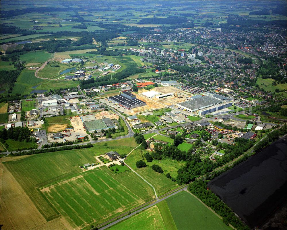 Kamp-Lintfort from the bird's eye view: Deutlich sichtbar ist der Strukturwandel im Verlauf der letzten 30 Jahren haben sich hier technologieorientierte Betriebe etabliert, die den Steinkohlebergbau mittelfristig ablösen sollen. Im Gewerbegebiet an der Friedrich-Heinrich-Alle entsteht das Produktionszentrum des Mobiltefefonherstellers Siemens Mobile (heute BenQ Mobile). Unten ist eine Kohlenhalde des Bergwerks West erkennbar. Structural change in the industrial area of Kamp - Lintfort.