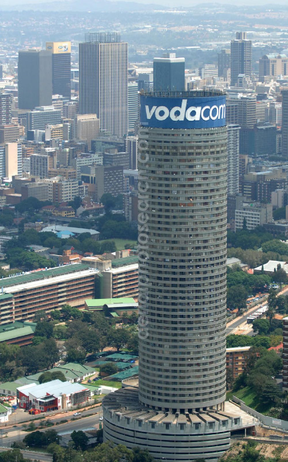 Johannesburg from above - Blick auf den Strydom Tower (Ponte City Apartments) an der Saratoga Ace / Joe Slovo Dr in Johannesburg. Das Hochhaus ist durch seine weithin sichtbare vodacom - Leuchtreklame erkennbar und ein Markenzeichen der Stadt. View of the Strydom Tower (Ponte City Apartments) at the Saratoga Ace / Joe Slovo Dr in Johannesburg. The skyscraper is visible for miles vodacom through his - neon sign and a recognizable brand in the city.