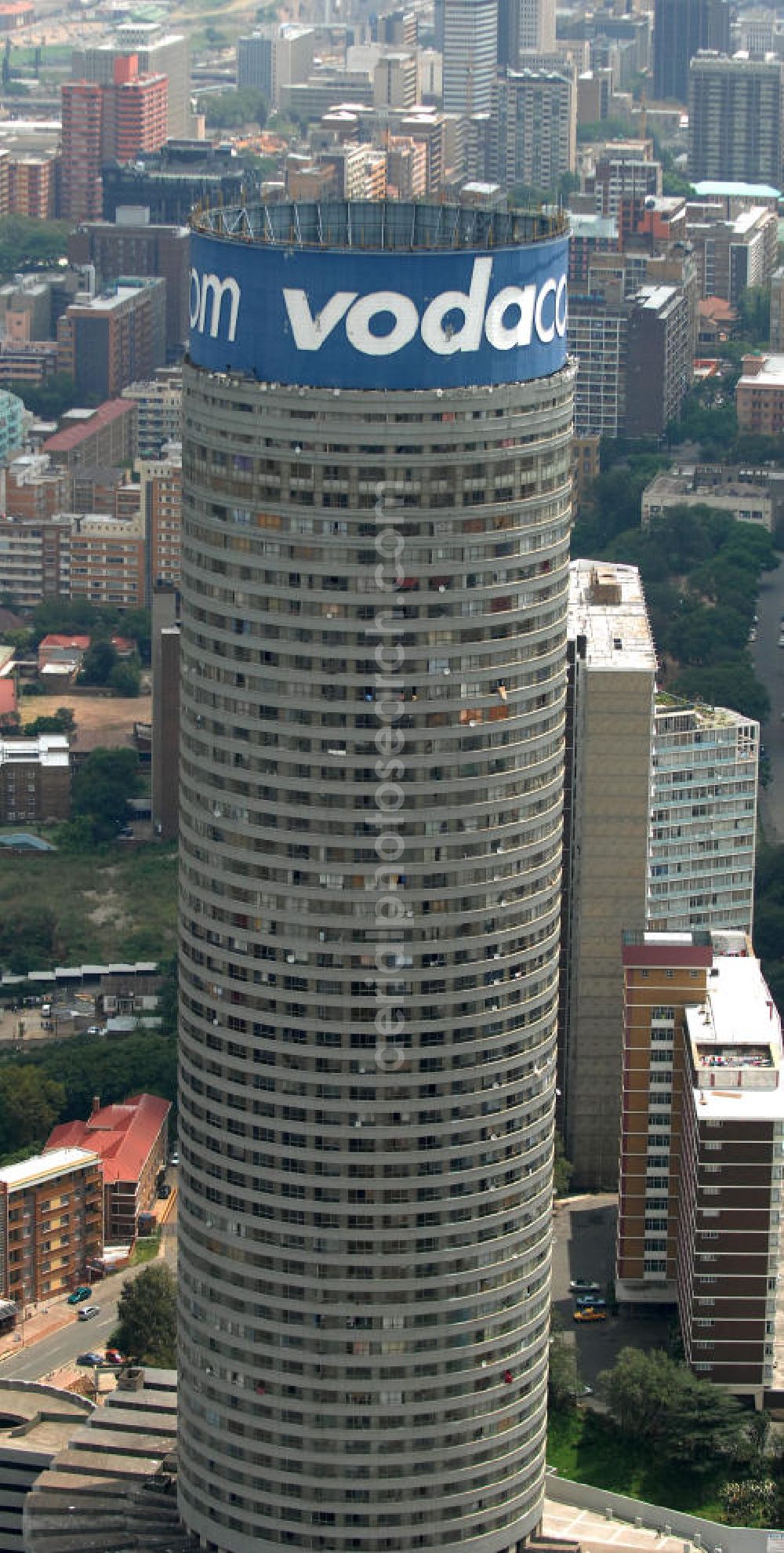 Aerial image Johannesburg - Blick auf den Strydom Tower (Ponte City Apartments) an der Saratoga Ace / Joe Slovo Dr in Johannesburg. Das Hochhaus ist durch seine weithin sichtbare vodacom - Leuchtreklame erkennbar und ein Markenzeichen der Stadt. View of the Strydom Tower (Ponte City Apartments) at the Saratoga Ace / Joe Slovo Dr in Johannesburg. The skyscraper is visible for miles vodacom through his - neon sign and a recognizable brand in the city.