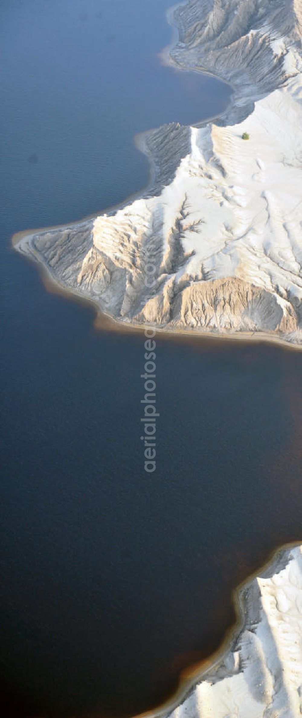 Bluno from the bird's eye view: Tagebaulandschaft mit Abraumhalden am Blunoer Südsee (obersorbisch Juzny Blunjanski jezor) ist ein Tagebaurestsee der Lausitzer Seenkette im sächsischen Teil des Lausitzer Seenlandes, auf dem Gebiet der Gemeinde Elsterheide. Seinen Namen verdankt der See einerseits seiner Lage südlich des Ortes Bluno. Der See entstand durch Flutung des Restlochs „ Nordschlauch “ des Tagebaues Spreetal. Lusatian lake district in the Saxon part of the Lusatian Lake District.