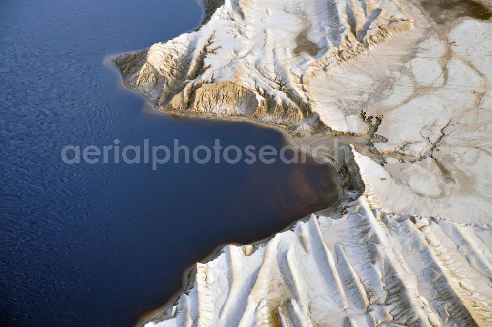 Aerial image Bluno - Tagebaulandschaft mit Abraumhalden am Blunoer Südsee (obersorbisch Juzny Blunjanski jezor) ist ein Tagebaurestsee der Lausitzer Seenkette im sächsischen Teil des Lausitzer Seenlandes, auf dem Gebiet der Gemeinde Elsterheide. Seinen Namen verdankt der See einerseits seiner Lage südlich des Ortes Bluno. Der See entstand durch Flutung des Restlochs „ Nordschlauch “ des Tagebaues Spreetal. Lusatian lake district in the Saxon part of the Lusatian Lake District.