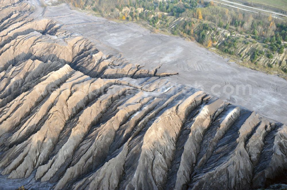 Aerial photograph Haidemühl - Tagebaulandschaft mit Abraumhalden am Tagebau Welzow-Süd. Die einer Mondlandschaft ähnlichen Erdmassen sollen im Zuge der mittelfristigen Renaturierung der Braunkohletagebauflächen mit Bewuchs versehen werden. Der immer noch aktiver Vattenfall - Tagebau Welzow-Süd fördert pro Sekunde eine Tonne Kohle zu Tage. Landscape with open pit mining dumps at Welzow-South.