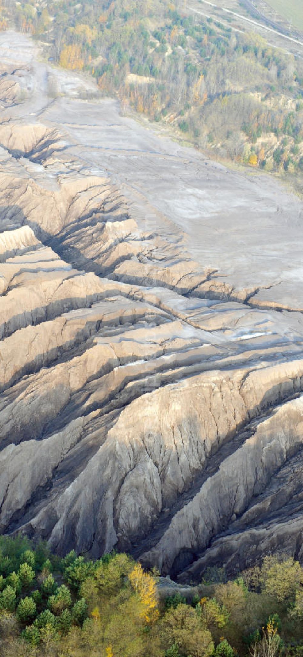 Aerial photograph Haidemühl - Tagebaulandschaft mit Abraumhalden am Tagebau Welzow-Süd. Die einer Mondlandschaft ähnlichen Erdmassen sollen im Zuge der mittelfristigen Renaturierung der Braunkohletagebauflächen mit Bewuchs versehen werden. Der immer noch aktiver Vattenfall - Tagebau Welzow-Süd fördert pro Sekunde eine Tonne Kohle zu Tage. Landscape with open pit mining dumps at Welzow-South.