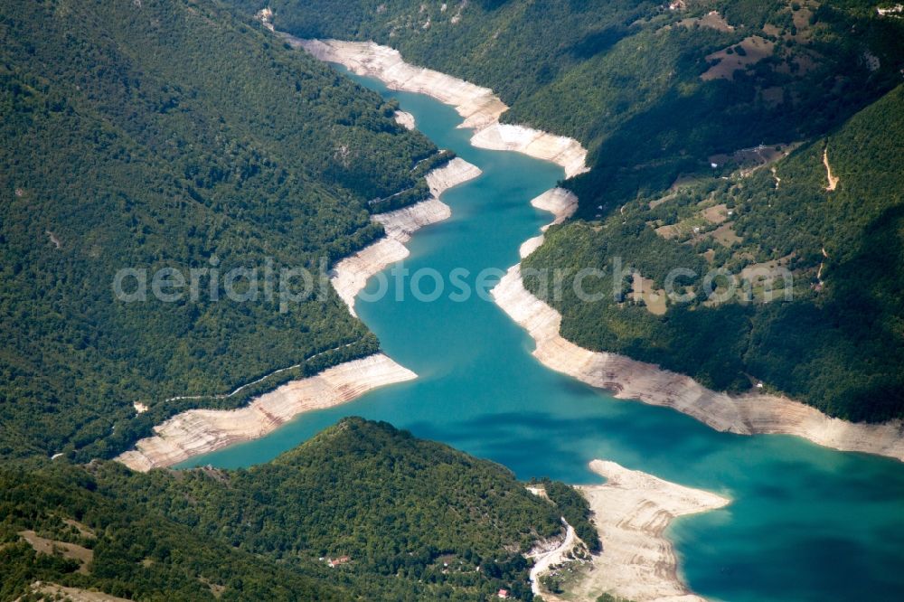 Aerial photograph Plužine - Dam and shore areas at the lake in Plužine in Montenegro. The Pivsko Lake is a reservoir in northwestern of Montenegro and is the largest dam in the country. The reservoir flooded the original site of the Piva monastery