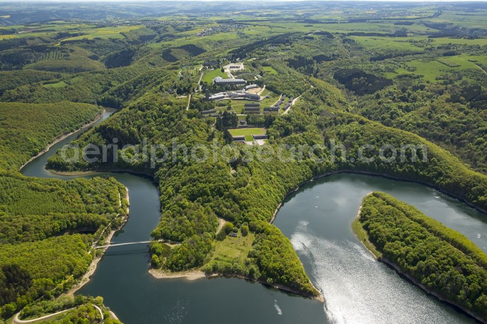 Aerial image Schleiden - Dam and shore areas at the lake Urfttalsperre near Schleiden in the state North Rhine-Westphalia. In view of the complex of buildings of the former Nazi Ordensburg Vogelsang, later barracks of the Belgian armed forces and today's Meeting Centre International Place in the Eifel National Park