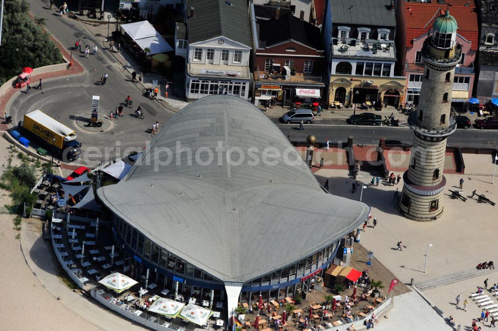 Rostock - Warnemünde from above - Blick auf die den Teepott mit dem alten Leuchtturman der Seepromenade des Ostseestrandes von Warnemünde. Der 1967 errichtete Teepott neben dem Leuchtturm an der Warnemünder Seepromenade erbaute Einzelbau ist ein Beispiel für die Hyparschalenarchitektur der 1960er Jahre. Er beherbergt unter an derem zwei Restaurants und eine ständige Ausstellung des Weltenbummlers Reinhold Kasten. Views of the lake with the Teepott and the old lighthouse at the Baltic Sea beach of Warnemünde.