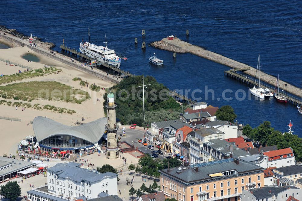 Rostock - Warnemünde from above - Blick auf die den Teepott mit dem alten Leuchtturman der Seepromenade des Ostseestrandes von Warnemünde. Der 1967 errichtete Teepott neben dem Leuchtturm an der Warnemünder Seepromenade erbaute Einzelbau ist ein Beispiel für die Hyparschalenarchitektur der 1960er Jahre. Er beherbergt unter an derem zwei Restaurants und eine ständige Ausstellung des Weltenbummlers Reinhold Kasten. Views of the lake with the Teepott and the old lighthouse at the Baltic Sea beach of Warnemünde.