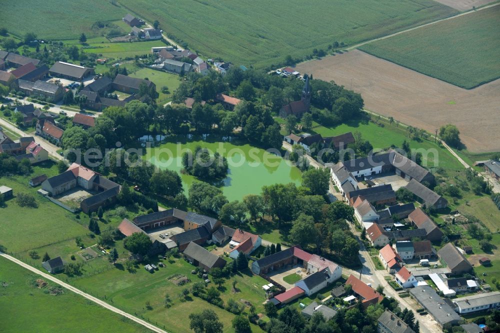 Borgisdorf from above - Pond in the centre of the village of Borgisdorf in the state of Brandenburg. The pond with its small island is located in the centre of the village in the county district of Teltow-Flaeming