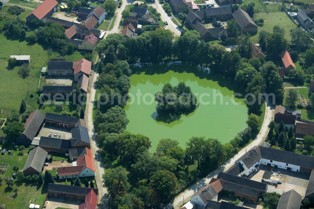 Aerial photograph Borgisdorf - Pond in the centre of the village of Borgisdorf in the state of Brandenburg. The pond with its small island is located in the centre of the village in the county district of Teltow-Flaeming