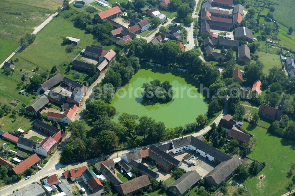 Borgisdorf from above - Pond in the centre of the village of Borgisdorf in the state of Brandenburg. The pond with its small island is located in the centre of the village in the county district of Teltow-Flaeming