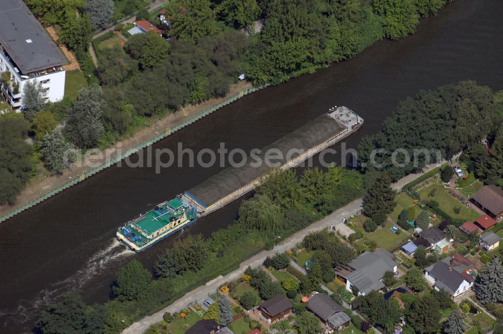 Aerial photograph Berlin - Blick auf ein Gütermotorschiff auf dem Teltowkanal. Der ca. 38km lange Teltowkanal fließt in Berlin und dem südlichen Berliner Umland. Er verbindet die Spree-Oder-Wasserstraße (Dahme, Nebenfluss der Spree) mit der Potsdamer Havel. Als Bundeswasserstraße verläuft der Kanal durch die Bundesländer Berlin und Brandenburg, und bildet teilweise ihre Landesgrenze. Die Wasserqualität ist nach wie vor schlecht, aufgrund des erhöhten PCP-Gehaltes sollte auch Angelfisch von hier nicht verspeist werden. Der Kanal wurde zwischen 1900 und 1906 angelegt und zum Britzer Verbindungskanal und dem Neuköllner Schiffahrtskanal eingeplant.