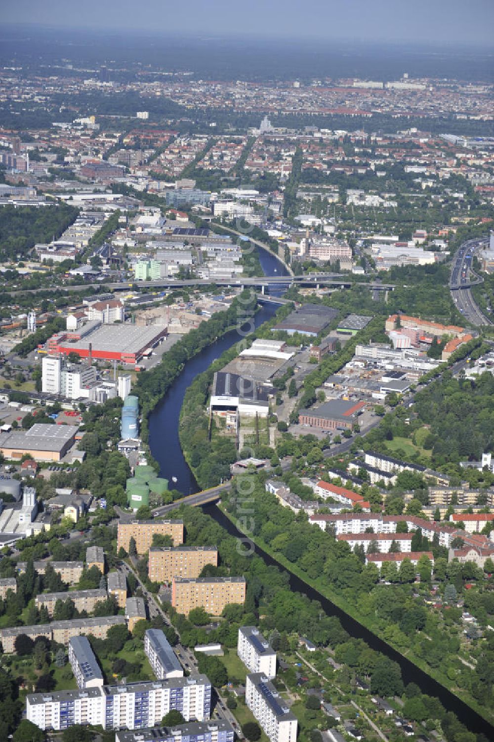 Berlin from the bird's eye view: Look at the Teltow sewer, the industrial area with the distribution point of Klinger and the building centre Hornbach Berlin-Neukölln and the St.-Simeon and St. Lukas chruchyard