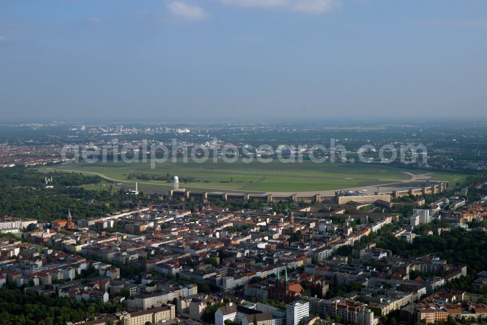 Berlin from the bird's eye view: Cityscape from Tempelhof to the terminal and former station building with arched place the air bridge at the disused airfield of Berlin Airport - Tempelhof. The grounds at Tempelhof airfield is managed by the state-owned BIM Berliner Immobilienmanagement GmbH