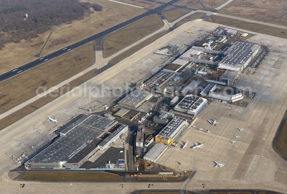 KÖLN from above - Terminal, Rollwege Start- und Landebahn am Flughafen Köln/Bonn „Konrad Adenauer“ in Köln in Nordrhein-Westfalen. Der Flughafen Köln / Bonn „Konrad Adenauer“ (IATA: CGN, ICAO: EDDK, auch Köln Bonn Airport oder Flughafen Köln-Wahn) ist ein deutscher Verkehrsflughafen und liegt am südöstlichen Stadtrand von Köln und zum Teil in Troisdorf. Das Flughafengelände wird vom Naturschutzgebiet Wahner Heide umschlossen, diesem aber nicht zugerechnet.Obwohl Köln/Bonn in den 60er Jahren als Interkontinentalflughafen geplant wurde, wurden Langstreckenflüge in der Regel nur saisonweise zu Urlaubsdestinationen angeboten. 2006 gab es nach 15 Jahren wieder die ersten interkontinentalen Linienflüge in die USA. Das Luftfracht-Unternehmen UPS nutzt Köln/Bonn als seinen Europa-Hub.