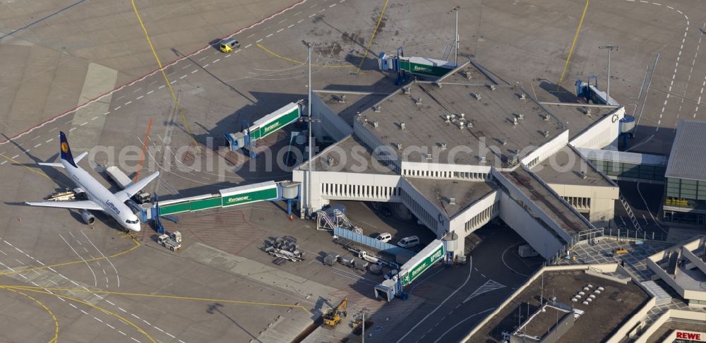 Aerial photograph KÖLN - Terminal, Rollwege Start- und Landebahn am Flughafen Köln/Bonn „Konrad Adenauer“ in Köln in Nordrhein-Westfalen. Der Flughafen Köln / Bonn „Konrad Adenauer“ (IATA: CGN, ICAO: EDDK, auch Köln Bonn Airport oder Flughafen Köln-Wahn) ist ein deutscher Verkehrsflughafen und liegt am südöstlichen Stadtrand von Köln und zum Teil in Troisdorf. Das Flughafengelände wird vom Naturschutzgebiet Wahner Heide umschlossen, diesem aber nicht zugerechnet.Obwohl Köln/Bonn in den 60er Jahren als Interkontinentalflughafen geplant wurde, wurden Langstreckenflüge in der Regel nur saisonweise zu Urlaubsdestinationen angeboten. 2006 gab es nach 15 Jahren wieder die ersten interkontinentalen Linienflüge in die USA. Das Luftfracht-Unternehmen UPS nutzt Köln/Bonn als seinen Europa-Hub.