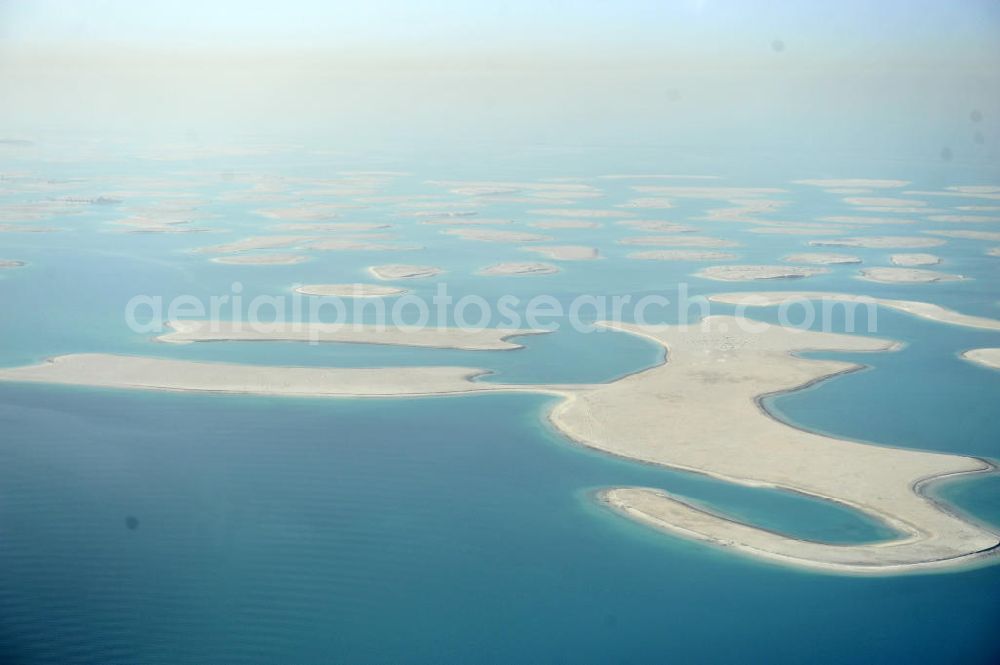 Dubai from the bird's eye view: Blick auf einen Teil der Inselgruppe The World. The World oder World Islands ist eine auf der Basis von Felsschüttungen aus verdichtetem Sand aufgespülte künstliche Inselgruppe, die die groben Umrisse der Weltkarte darstellen sollen. Sie befindet sich 4,0 km (2,5 Meilen) vor der Küste Dubais, Vereinigte Arabische Emirate und besteht aus mehreren verscheidenen kleineren Inseln. View of a part of the archipelago The World. The World or World Islands is an artificial archipelago of various small islands constructed in the rough shape of a world map, located 4,0 km (2.5 mi) off the coast of Dubai, United Arab Emirates.