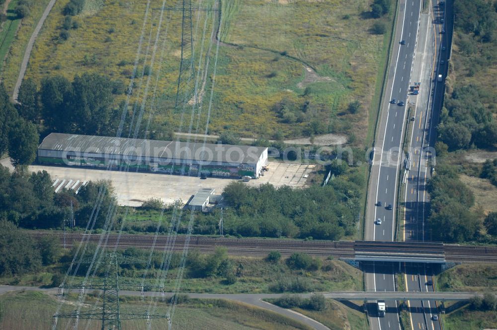 Berlin from the bird's eye view: Blick durch Stromleitungen auf eine Halle für Einsatzfahrzeuge des THW auf dem Geländes des Technischen Hilfswerk, Ortsverband Berlin Pankow an der Wiltbergstraße neben dem Berliner Ring / Autobahn A 10 / E 55 und den Schienen der Bahnlinen S2, RE3 und RB60 in Buch. Das Gelände diente ehemals als Hauptsitz der Zivilverteidigung der DDR.