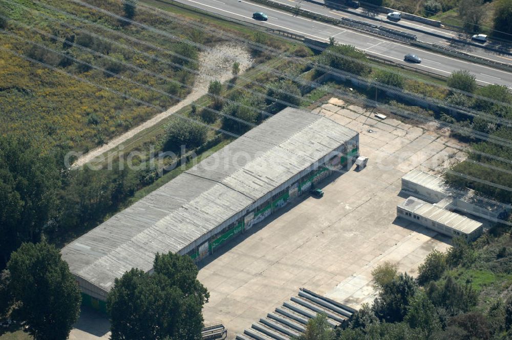 Berlin from the bird's eye view: Blick durch Stromleitungen auf eine Halle für Einsatzfahrzeuge des THW auf dem Geländes des Technischen Hilfswerk, Ortsverband Berlin Pankow an der Wiltbergstraße neben dem Berliner Ring / Autobahn A 10 / E 55 in Buch. Das Gelände diente ehemals als Hauptsitz der Zivilverteidigung der DDR.