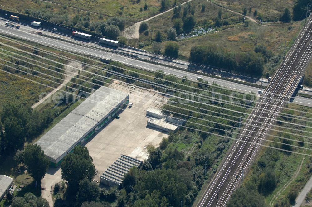 Berlin from the bird's eye view: Blick durch Stromleitungen auf eine Halle für Einsatzfahrzeuge des THW auf dem Geländes des Technischen Hilfswerk, Ortsverband Berlin Pankow an der Wiltbergstraße neben dem Berliner Ring / Autobahn A 10 / E 55 und den Schienen der Bahnlinen S2, RE3 und RB60 in Buch. Das Gelände diente ehemals als Hauptsitz der Zivilverteidigung der DDR.