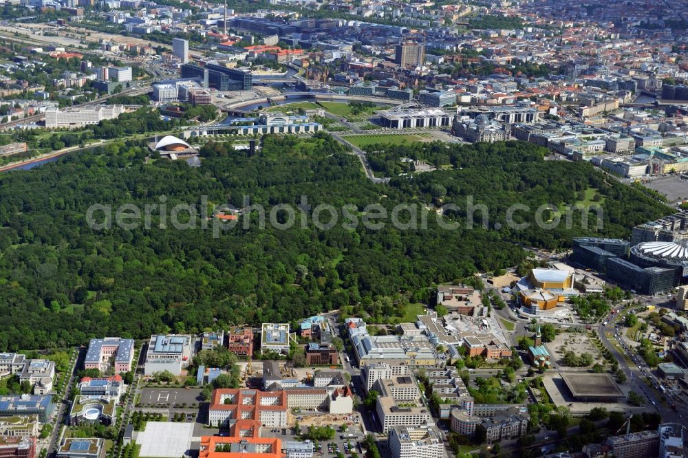 Aerial photograph Berlin - As a large central park, the Tiergarten is located in the homonymous district of Berlin. The green area of ??the Straße des 17 June is divided at its eastern end is the Brandenburg Gate. Striking is the House of World Cultures. The Pregnant Oyster also called building was built as part of the international building exhibition. North of the Tiergarten, the buildings on the government district close to the Chancellery and the Reichstag building. Not far from the Spree the main train station and the high-rise building of the University Hospital Charité are to recognize . At the Tiergartenstraße a number of embassies have their headquarters, the Turkish Embassy, the Italian Embassy and the Japanese Embassy. Not far from the embassy district is the Cultural Forum, the Philharmonic Hall and the striking buildings at Potsdamer Platz, such as the Sony Center