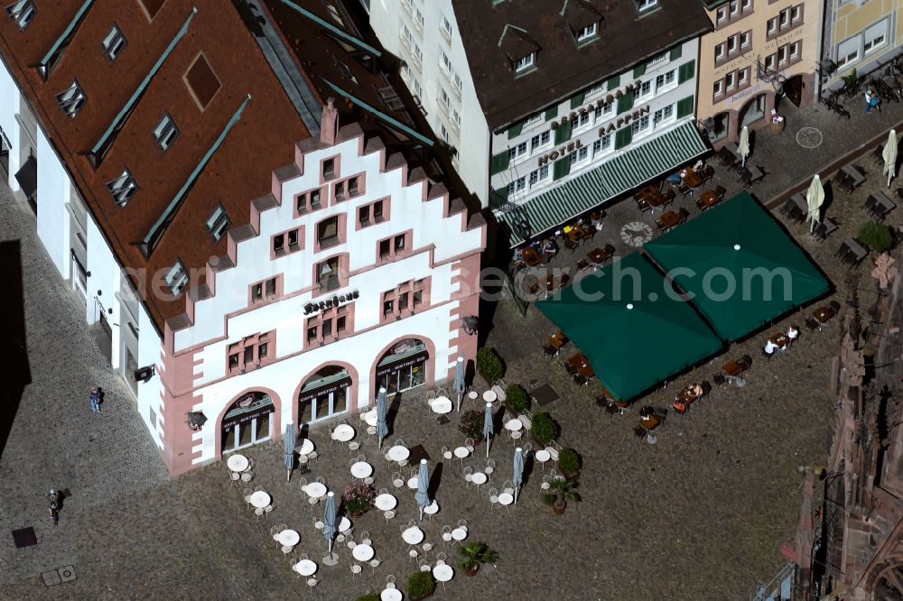 Freiburg im Breisgau from above - Tables and benches of open-air restaurant SamS Cafe in Kornhaus on place Muensterplatz in Freiburg im Breisgau in the state Baden-Wuerttemberg, Germany