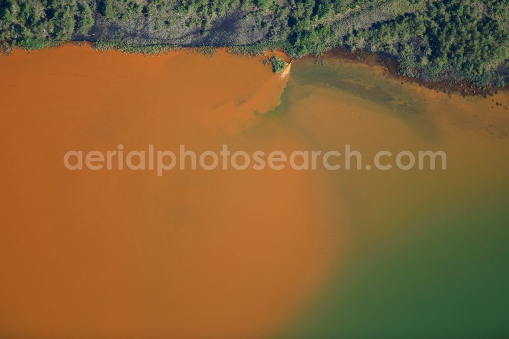 Aerial photograph Schwarzheide - Pond water surface and pond oasis with brightly colored discharges from the nearby chemical industry and sediment deposits in Schwarzheide in the state of Brandenburg, Germany