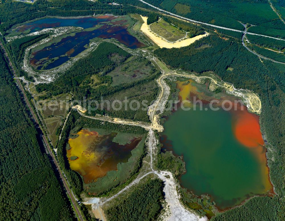 Aerial photograph Schwarzheide - Pond water surface and pond oasis with brightly colored discharges from the nearby chemical industry and sediment deposits in Schwarzheide in the state of Brandenburg, Germany