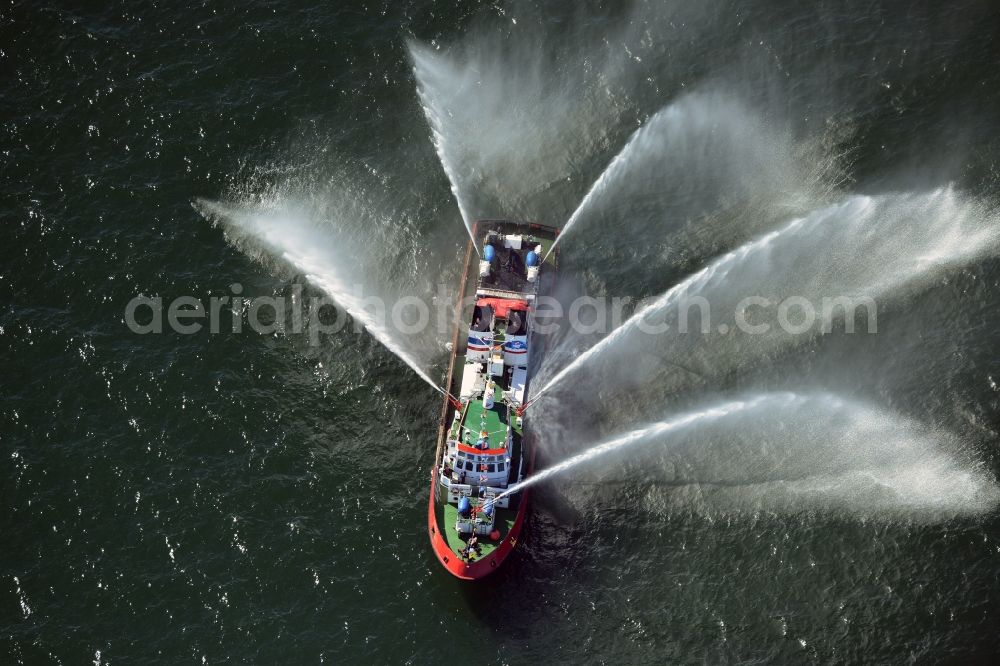 Rostock from the bird's eye view: Water fountains of traditional fire extinguishing ship welcoming the sailing ships of the Hanse Sail maritime leak on the Baltic Sea in Rostock in Mecklenburg - Western Pomerania