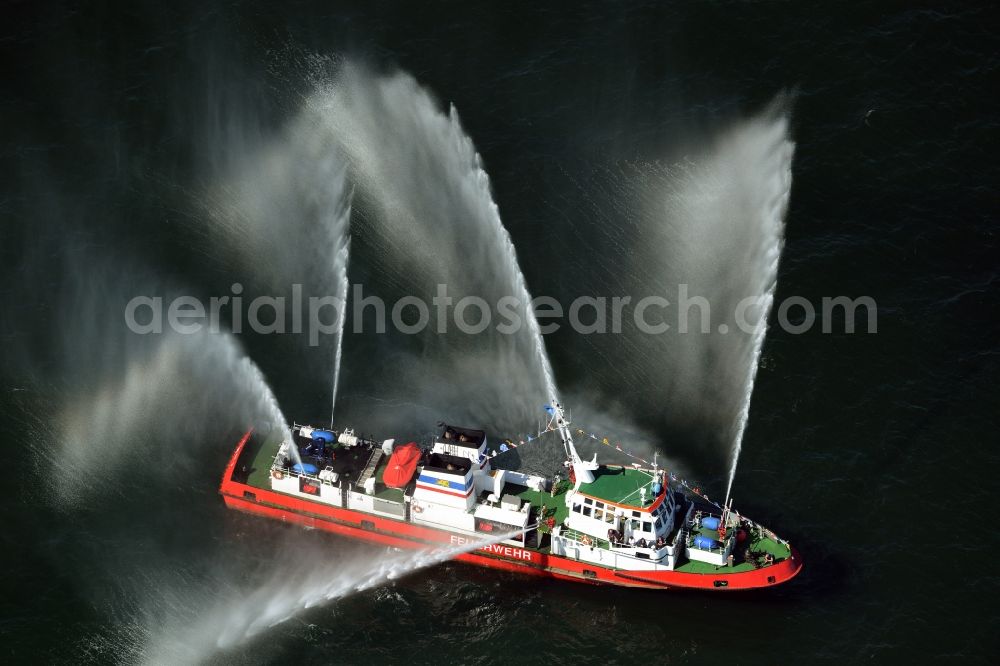 Aerial image Rostock - Water fountains of traditional fire extinguishing ship welcoming the sailing ships of the Hanse Sail maritime leak on the Baltic Sea in Rostock in Mecklenburg - Western Pomerania