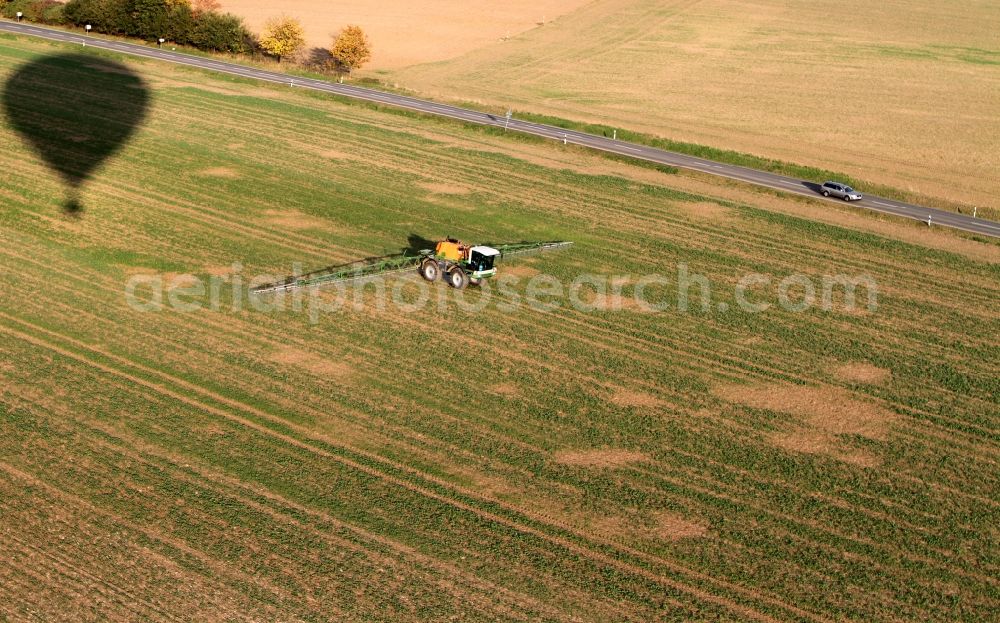 Niederdorla from the bird's eye view: Tractor with fertilizer bridge on a field / farm at Niederdorla in Thuringia