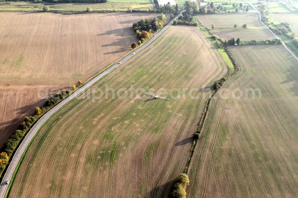 Aerial image Niederdorla - Tractor with fertilizer bridge on a field / farm at Niederdorla in Thuringia