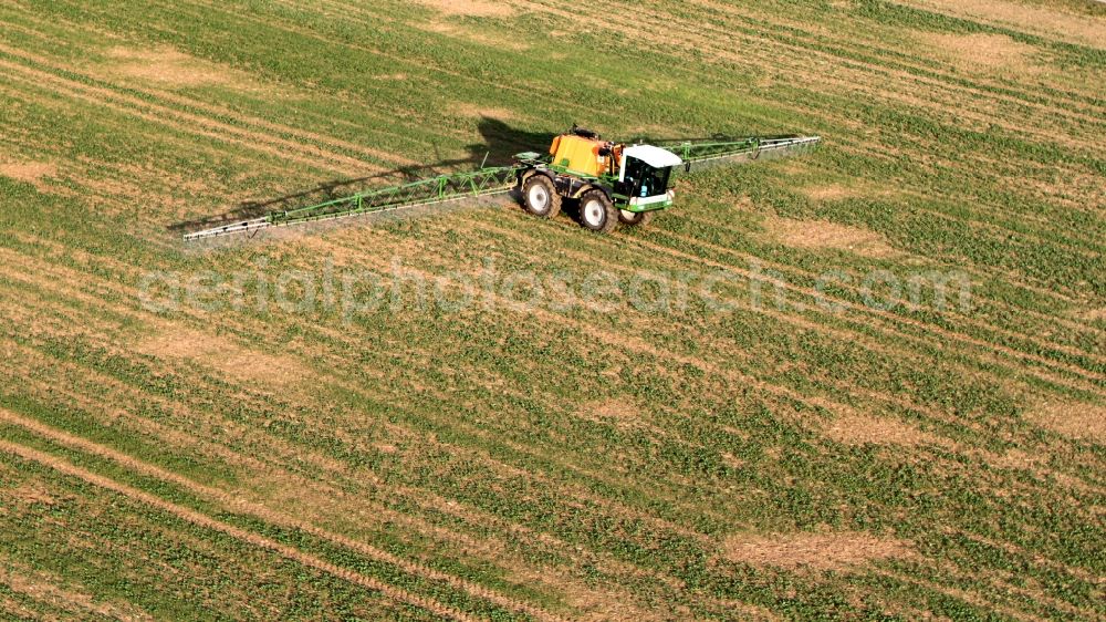 Niederdorla from above - Tractor with fertilizer bridge on a field / farm at Niederdorla in Thuringia