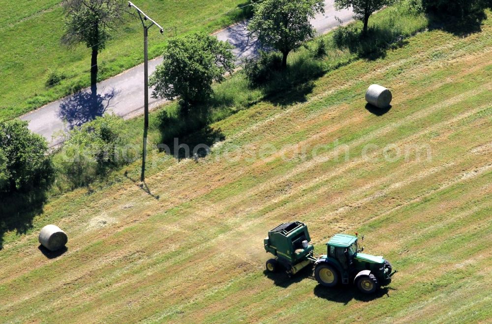 Aerial photograph Gösselborn - View of a tractor in a field in Gösselborn in the district Ilm - Kreis in the state of Thuringia. The tractor produced with a baler hay bales