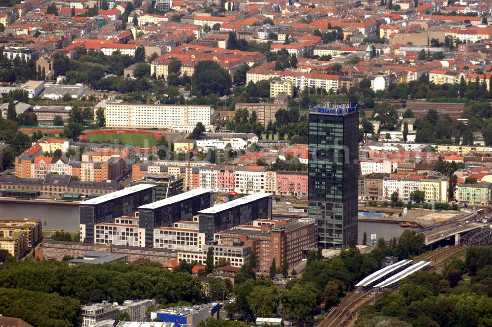 Berlin from the bird's eye view: Blick auf die Treptowers im Bezirk Alt-Treptow, nahe dem S-Bahnhof Treptower Park und der Spree. Ansässig An den Treptowers 3, bilden die Treptowers einen Büro- und Dienstleistungsstandort bestehend aus verschiedenen Gebäuden, wie dem Allianz Tower, dem höchsten Bürogebäude Berlins. Im Bildhintergrund befindet sich ein Ausschnitt von Friedrichshain-Kreuzberg. Das auffälligste dabei ist der Lasker Sportplatz in der Persiusstraße 7, der Sportmöglichkeiten für Fußball, Volleyball, Handball und Leichtathletik bietet und sich mitten im Wohngebiet befindet. Kontakt: