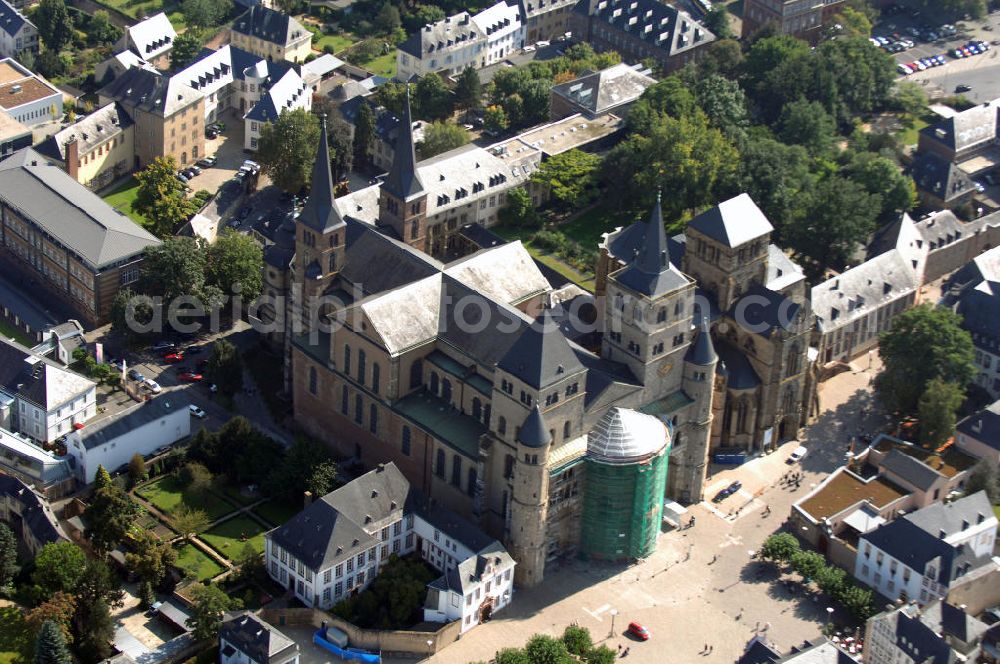 TRIER from above - Trierer Dom, St. Gangolf und die Liebfrauenkirche in Trier. Die Hohe Domkirche St. Peter zu Trier ist die älteste Bischofskirche Deutschlands und die Mutterkirche des Bistums Trier. Das bedeutende sakrale Bauwerk abendländischer Baukunst steht seit 1986 zusammen mit der unmittelbar benachbarten Liebfrauenkirche auf der UNESCO-Liste des Weltkulturerbes. Mit einer Länge von 112,5 Metern und einer Breite von 41 Metern ist der Dom das größte Kirchengebäude der Stadt Trier.Der Dom steht über den Resten eines prächtigen römischen Wohnhauses. Nach dem Übertritt des römischen Kaisers Konstantin zum Christentum wurde eine Basilika errichtet, die unter Bischof Maximin (329–346) zu einer der größten Kirchenanlagen Europas mit vier Basiliken, einem Baptisterium und Nebengebäuden erweitert wurde.