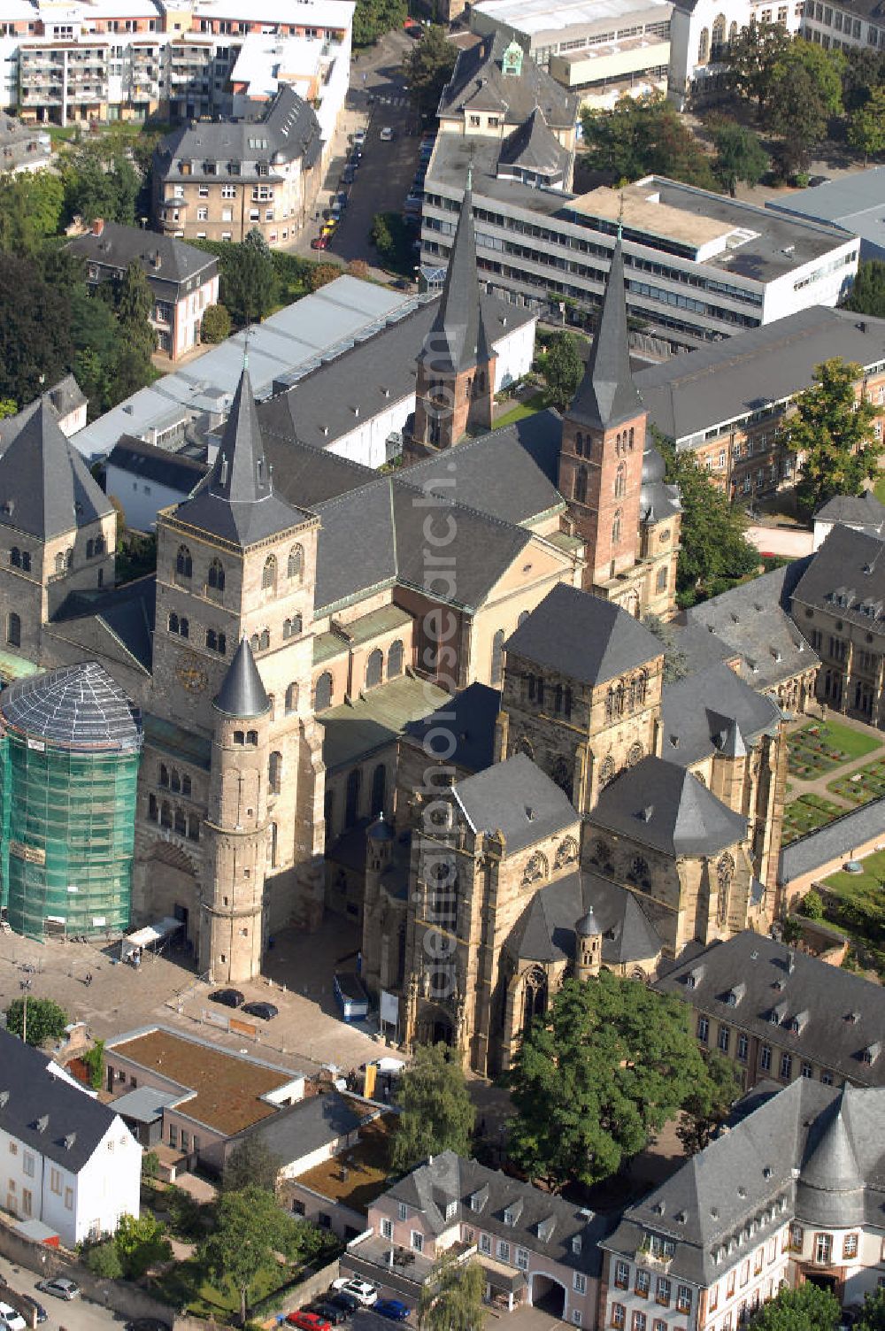 Aerial photograph TRIER - Trierer Dom, St. Gangolf und die Liebfrauenkirche in Trier. Die Hohe Domkirche St. Peter zu Trier ist die älteste Bischofskirche Deutschlands und die Mutterkirche des Bistums Trier. Das bedeutende sakrale Bauwerk abendländischer Baukunst steht seit 1986 zusammen mit der unmittelbar benachbarten Liebfrauenkirche auf der UNESCO-Liste des Weltkulturerbes. Mit einer Länge von 112,5 Metern und einer Breite von 41 Metern ist der Dom das größte Kirchengebäude der Stadt Trier.Der Dom steht über den Resten eines prächtigen römischen Wohnhauses. Nach dem Übertritt des römischen Kaisers Konstantin zum Christentum wurde eine Basilika errichtet, die unter Bischof Maximin (329–346) zu einer der größten Kirchenanlagen Europas mit vier Basiliken, einem Baptisterium und Nebengebäuden erweitert wurde.