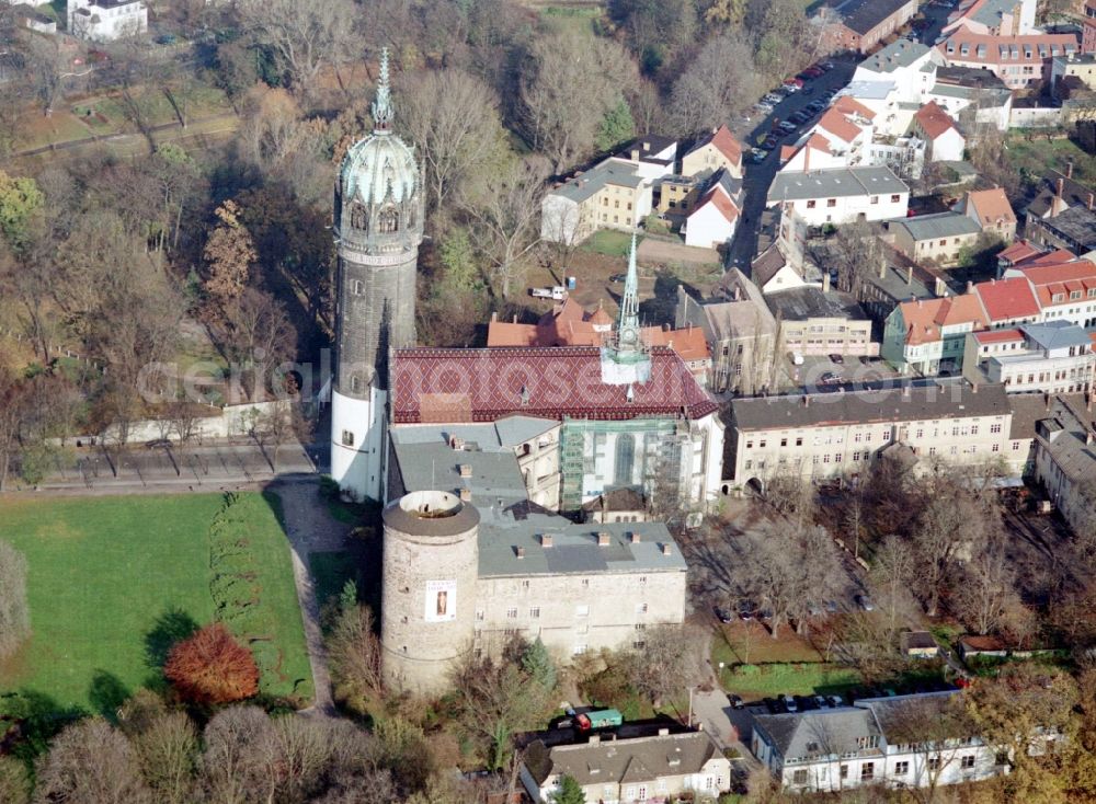 Aerial image Lutherstadt Wittenberg - Castle church of Wittenberg. The castle with its 88 m high Gothic tower at the west end of the town is a UNESCO World Heritage Site. It gained fame as the Wittenberg Augustinian monk and theology professor Martin Luther spread his disputation