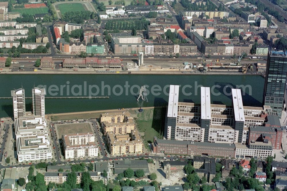 Berlin from above - The shore of the eastern harbor between Berlin-Kreuzberg and Berlin-Friedrichshain is characterized by the high-rise twin tower and Treptower and the Molecule Man sculpture by Jonathan Borofsky