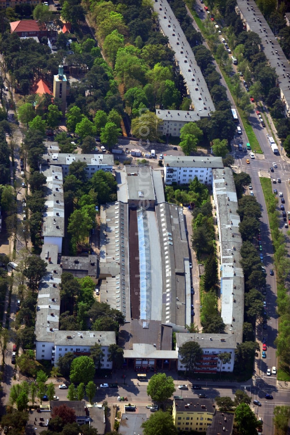 Aerial photograph Berlin - In the borough of Zehlendorf on the Argentine Avenue is the BvG Metro Station Uncle Tom's Cabin. The complex of buildings with row of shops and apartments was built to designs by the architect Alfred Grenan der and is today managed by the company Ansoreg property