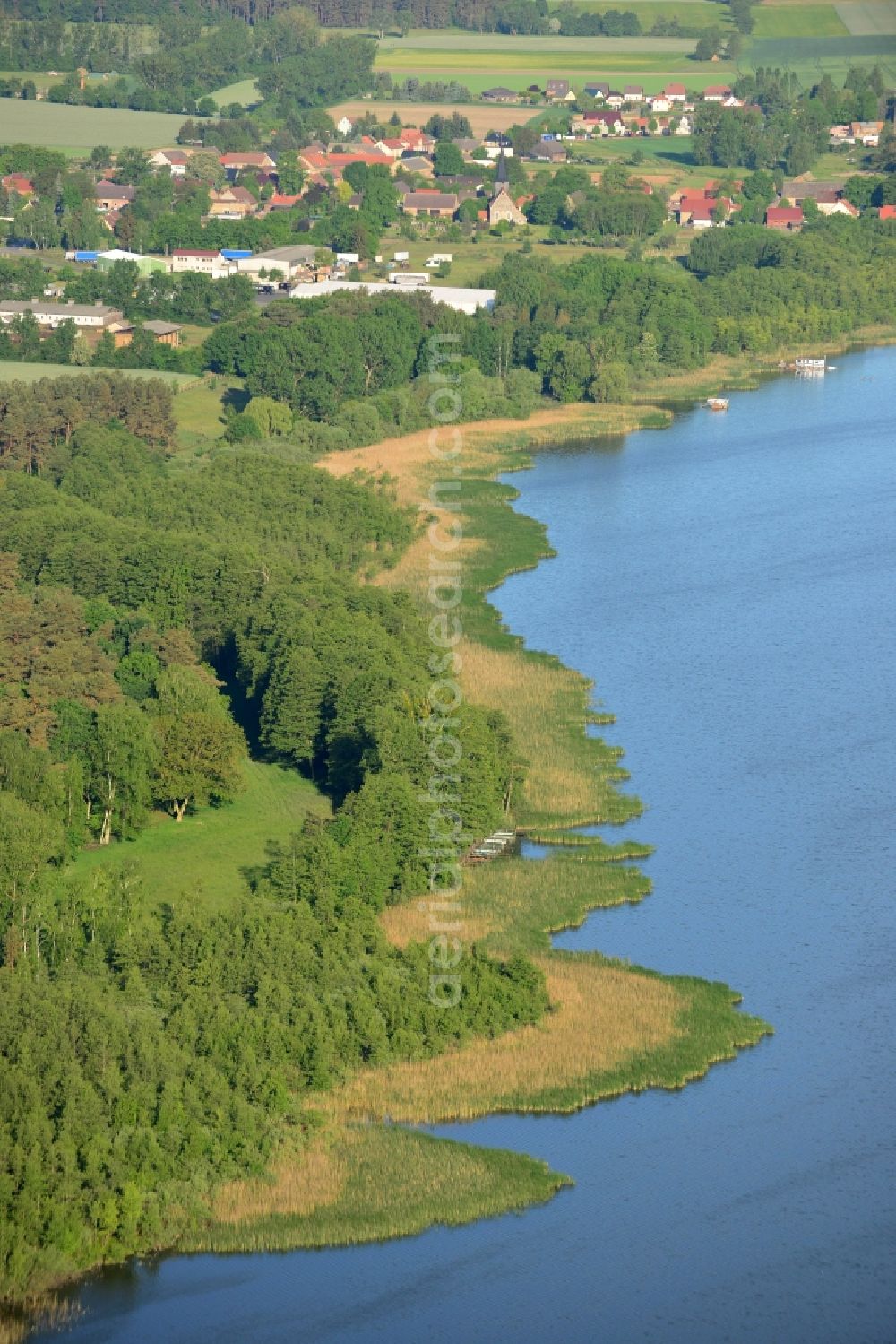Aerial photograph Löwenberger Land - Shores of Dreetzsee lake in the borough of Loewenberger Land in the state of Brandenburg. The lake is surrounded by trees and forest, the next village is the Grueneberg part of the borough. The background shows the Teschendorf part