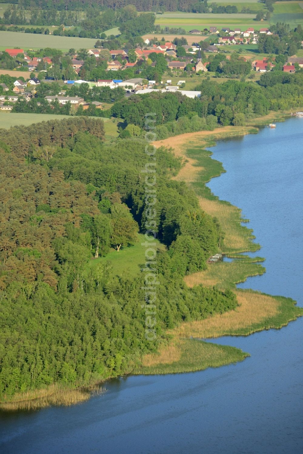 Aerial image Löwenberger Land - Shores of Dreetzsee lake in the borough of Loewenberger Land in the state of Brandenburg. The lake is surrounded by trees and forest, the next village is the Grueneberg part of the borough. The background shows the Teschendorf part
