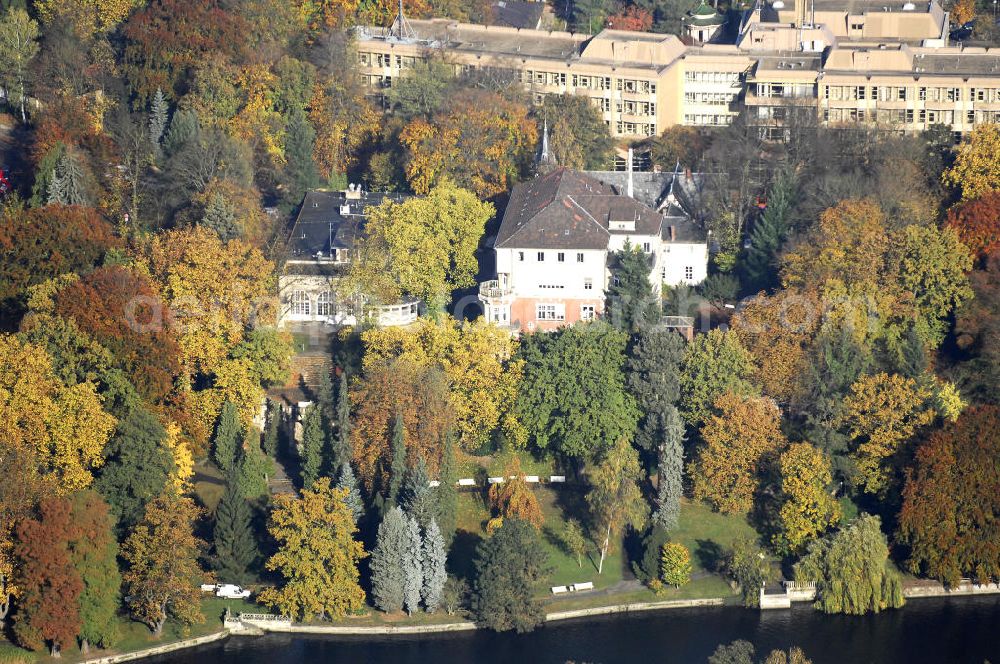 Berlin from the bird's eye view: Blick auf den uferbereich an der Villa Siemens Am Kleinen Wannsee direkt gegenüber des Neubaus zum Immanuel-Krankenhauses in Berlin-Wannsee. Das Krankenhaus gehört zur Immanuel Diakonie Group (IDG), die eine Einrichtung der Evangelisch-Freikirchlichen Gemeinde Berlin-Schöneberg ist. Die Verwaltung der IDG hatte ihren Sitz in der Villa Siemens. Das Gebäude war einst eine Sommerresidenz von Arnold von Siemens, dem ältesten Sohn des Firmengründers Werner von Siemens. Die Architekten waren Paul und Walther Hentschel, 1888 wurde der Bau fertiggestellt. Die Villa Siemens gehörte zur Colonie Alsen, einer Siedlung für das Berliner Großbürgertum, die Wilhelm Conrad 1863 gegründet hatte. Nach dem Zweiten Weltkrieg stifteten Hermann und Charlotte von Siemens die Villa der Baptisten-Gemeinde mit der Auflage, sie für soziale Zwecke zu nutzen. Es ist das einzige Ensemble von Gebäude und Park der ehemaligen Kolonie, das bis heute erhalten geblieben ist. Der Krankenhausbetrieb ist jetzt in einem Neubau auf der gegenüberliegenden Straßenseite untergebracht. Das ehemals zum Areal gehörende Anwesen Am kleinen Wannsee Nr 4 wurde verkauft. ISA Immobilien Service Agentur GmbH, Herr Roland Kober