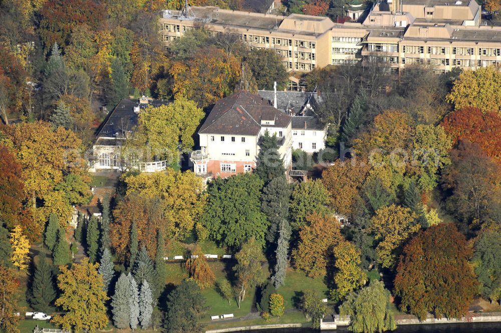 Aerial image Berlin - Blick auf den uferbereich an der Villa Siemens Am Kleinen Wannsee direkt gegenüber des Neubaus zum Immanuel-Krankenhauses in Berlin-Wannsee. Das Krankenhaus gehört zur Immanuel Diakonie Group (IDG), die eine Einrichtung der Evangelisch-Freikirchlichen Gemeinde Berlin-Schöneberg ist. Die Verwaltung der IDG hatte ihren Sitz in der Villa Siemens. Das Gebäude war einst eine Sommerresidenz von Arnold von Siemens, dem ältesten Sohn des Firmengründers Werner von Siemens. Die Architekten waren Paul und Walther Hentschel, 1888 wurde der Bau fertiggestellt. Die Villa Siemens gehörte zur Colonie Alsen, einer Siedlung für das Berliner Großbürgertum, die Wilhelm Conrad 1863 gegründet hatte. Nach dem Zweiten Weltkrieg stifteten Hermann und Charlotte von Siemens die Villa der Baptisten-Gemeinde mit der Auflage, sie für soziale Zwecke zu nutzen. Es ist das einzige Ensemble von Gebäude und Park der ehemaligen Kolonie, das bis heute erhalten geblieben ist. Der Krankenhausbetrieb ist jetzt in einem Neubau auf der gegenüberliegenden Straßenseite untergebracht. Das ehemals zum Areal gehörende Anwesen Am kleinen Wannsee Nr 4 wurde verkauft. ISA Immobilien Service Agentur GmbH, Herr Roland Kober