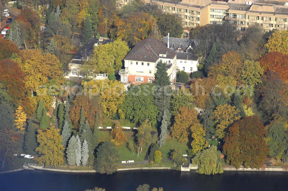 Aerial photograph Berlin - Blick auf den uferbereich an der Villa Siemens Am Kleinen Wannsee direkt gegenüber des Neubaus zum Immanuel-Krankenhauses in Berlin-Wannsee. Das Krankenhaus gehört zur Immanuel Diakonie Group (IDG), die eine Einrichtung der Evangelisch-Freikirchlichen Gemeinde Berlin-Schöneberg ist. Die Verwaltung der IDG hatte ihren Sitz in der Villa Siemens. Das Gebäude war einst eine Sommerresidenz von Arnold von Siemens, dem ältesten Sohn des Firmengründers Werner von Siemens. Die Architekten waren Paul und Walther Hentschel, 1888 wurde der Bau fertiggestellt. Die Villa Siemens gehörte zur Colonie Alsen, einer Siedlung für das Berliner Großbürgertum, die Wilhelm Conrad 1863 gegründet hatte. Nach dem Zweiten Weltkrieg stifteten Hermann und Charlotte von Siemens die Villa der Baptisten-Gemeinde mit der Auflage, sie für soziale Zwecke zu nutzen. Es ist das einzige Ensemble von Gebäude und Park der ehemaligen Kolonie, das bis heute erhalten geblieben ist. Der Krankenhausbetrieb ist jetzt in einem Neubau auf der gegenüberliegenden Straßenseite untergebracht. Das ehemals zum Areal gehörende Anwesen Am kleinen Wannsee Nr 4 wurde verkauft. ISA Immobilien Service Agentur GmbH, Herr Roland Kober