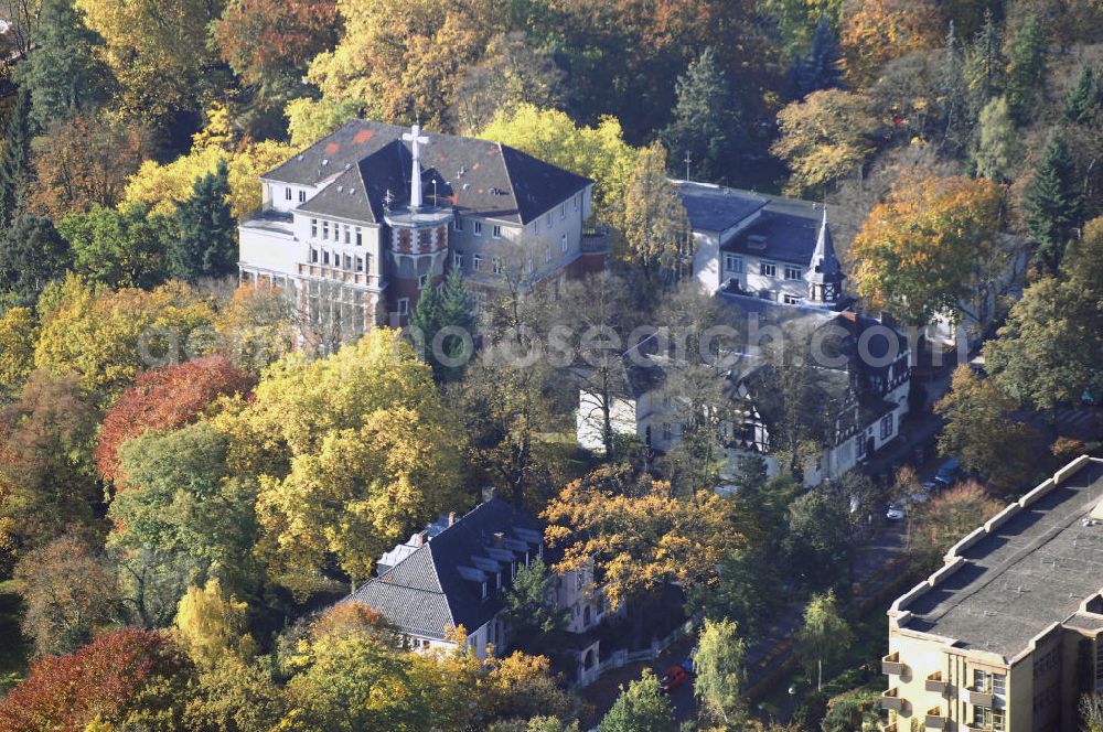 Aerial photograph Berlin - Blick auf den uferbereich an der Villa Siemens Am Kleinen Wannsee direkt gegenüber des Neubaus zum Immanuel-Krankenhauses in Berlin-Wannsee. Das Krankenhaus gehört zur Immanuel Diakonie Group (IDG), die eine Einrichtung der Evangelisch-Freikirchlichen Gemeinde Berlin-Schöneberg ist. Die Verwaltung der IDG hatte ihren Sitz in der Villa Siemens. Das Gebäude war einst eine Sommerresidenz von Arnold von Siemens, dem ältesten Sohn des Firmengründers Werner von Siemens. Die Architekten waren Paul und Walther Hentschel, 1888 wurde der Bau fertiggestellt. Die Villa Siemens gehörte zur Colonie Alsen, einer Siedlung für das Berliner Großbürgertum, die Wilhelm Conrad 1863 gegründet hatte. Nach dem Zweiten Weltkrieg stifteten Hermann und Charlotte von Siemens die Villa der Baptisten-Gemeinde mit der Auflage, sie für soziale Zwecke zu nutzen. Es ist das einzige Ensemble von Gebäude und Park der ehemaligen Kolonie, das bis heute erhalten geblieben ist. Der Krankenhausbetrieb ist jetzt in einem Neubau auf der gegenüberliegenden Straßenseite untergebracht. Das ehemals zum Areal gehörende Anwesen Am kleinen Wannsee Nr 4 wurde verkauft. ISA Immobilien Service Agentur GmbH, Herr Roland Kober