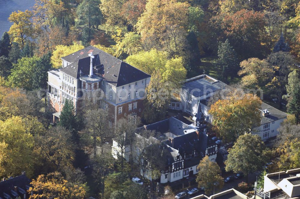 Berlin from the bird's eye view: Blick auf den uferbereich an der Villa Siemens Am Kleinen Wannsee direkt gegenüber des Neubaus zum Immanuel-Krankenhauses in Berlin-Wannsee. Das Krankenhaus gehört zur Immanuel Diakonie Group (IDG), die eine Einrichtung der Evangelisch-Freikirchlichen Gemeinde Berlin-Schöneberg ist. Die Verwaltung der IDG hatte ihren Sitz in der Villa Siemens. Das Gebäude war einst eine Sommerresidenz von Arnold von Siemens, dem ältesten Sohn des Firmengründers Werner von Siemens. Die Architekten waren Paul und Walther Hentschel, 1888 wurde der Bau fertiggestellt. Die Villa Siemens gehörte zur Colonie Alsen, einer Siedlung für das Berliner Großbürgertum, die Wilhelm Conrad 1863 gegründet hatte. Nach dem Zweiten Weltkrieg stifteten Hermann und Charlotte von Siemens die Villa der Baptisten-Gemeinde mit der Auflage, sie für soziale Zwecke zu nutzen. Es ist das einzige Ensemble von Gebäude und Park der ehemaligen Kolonie, das bis heute erhalten geblieben ist. Der Krankenhausbetrieb ist jetzt in einem Neubau auf der gegenüberliegenden Straßenseite untergebracht. Das ehemals zum Areal gehörende Anwesen Am kleinen Wannsee Nr 4 wurde verkauft. ISA Immobilien Service Agentur GmbH, Herr Roland Kober