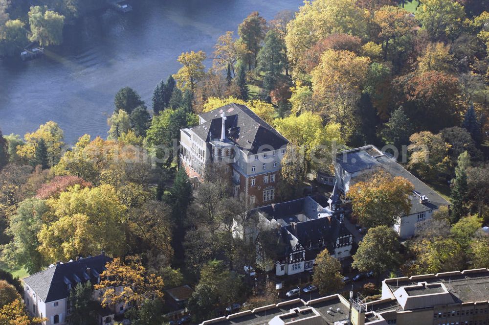 Berlin from above - Blick auf den uferbereich an der Villa Siemens Am Kleinen Wannsee direkt gegenüber des Neubaus zum Immanuel-Krankenhauses in Berlin-Wannsee. Das Krankenhaus gehört zur Immanuel Diakonie Group (IDG), die eine Einrichtung der Evangelisch-Freikirchlichen Gemeinde Berlin-Schöneberg ist. Die Verwaltung der IDG hatte ihren Sitz in der Villa Siemens. Das Gebäude war einst eine Sommerresidenz von Arnold von Siemens, dem ältesten Sohn des Firmengründers Werner von Siemens. Die Architekten waren Paul und Walther Hentschel, 1888 wurde der Bau fertiggestellt. Die Villa Siemens gehörte zur Colonie Alsen, einer Siedlung für das Berliner Großbürgertum, die Wilhelm Conrad 1863 gegründet hatte. Nach dem Zweiten Weltkrieg stifteten Hermann und Charlotte von Siemens die Villa der Baptisten-Gemeinde mit der Auflage, sie für soziale Zwecke zu nutzen. Es ist das einzige Ensemble von Gebäude und Park der ehemaligen Kolonie, das bis heute erhalten geblieben ist. Der Krankenhausbetrieb ist jetzt in einem Neubau auf der gegenüberliegenden Straßenseite untergebracht. Das ehemals zum Areal gehörende Anwesen Am kleinen Wannsee Nr 4 wurde verkauft. ISA Immobilien Service Agentur GmbH, Herr Roland Kober