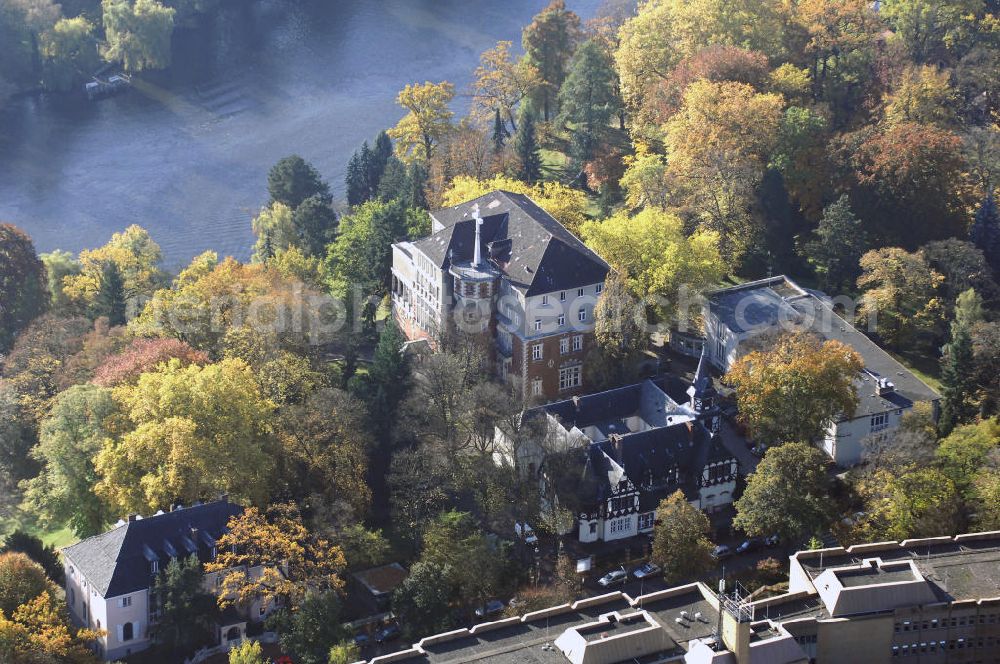 Berlin from the bird's eye view: Blick auf den uferbereich an der Villa Siemens Am Kleinen Wannsee direkt gegenüber des Neubaus zum Immanuel-Krankenhauses in Berlin-Wannsee. Das Krankenhaus gehört zur Immanuel Diakonie Group (IDG), die eine Einrichtung der Evangelisch-Freikirchlichen Gemeinde Berlin-Schöneberg ist. Die Verwaltung der IDG hatte ihren Sitz in der Villa Siemens. Das Gebäude war einst eine Sommerresidenz von Arnold von Siemens, dem ältesten Sohn des Firmengründers Werner von Siemens. Die Architekten waren Paul und Walther Hentschel, 1888 wurde der Bau fertiggestellt. Die Villa Siemens gehörte zur Colonie Alsen, einer Siedlung für das Berliner Großbürgertum, die Wilhelm Conrad 1863 gegründet hatte. Nach dem Zweiten Weltkrieg stifteten Hermann und Charlotte von Siemens die Villa der Baptisten-Gemeinde mit der Auflage, sie für soziale Zwecke zu nutzen. Es ist das einzige Ensemble von Gebäude und Park der ehemaligen Kolonie, das bis heute erhalten geblieben ist. Der Krankenhausbetrieb ist jetzt in einem Neubau auf der gegenüberliegenden Straßenseite untergebracht. Das ehemals zum Areal gehörende Anwesen Am kleinen Wannsee Nr 4 wurde verkauft. ISA Immobilien Service Agentur GmbH, Herr Roland Kober