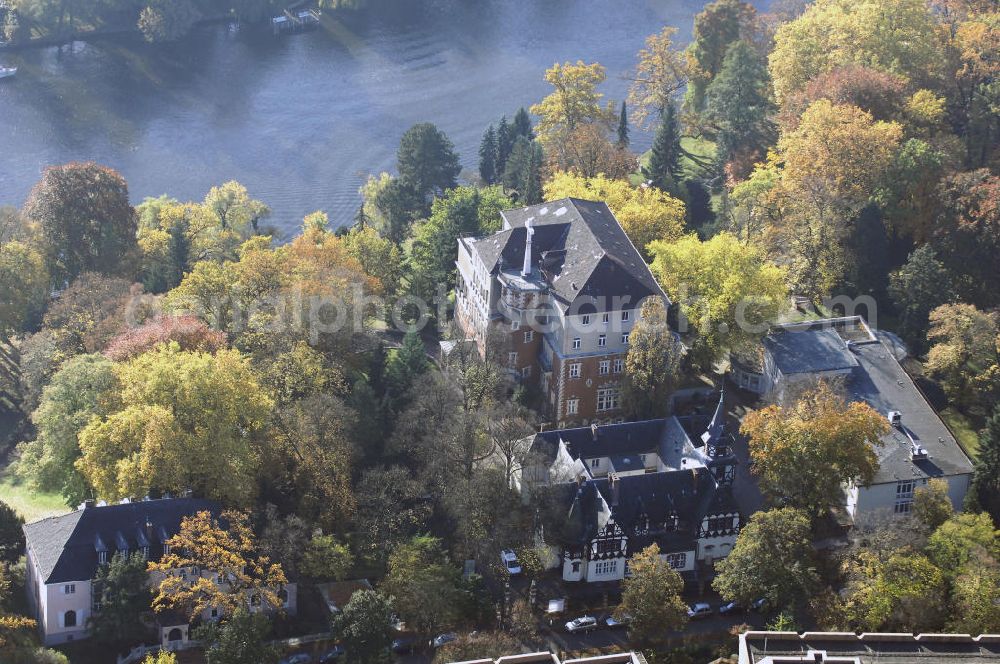 Aerial image Berlin - Blick auf den uferbereich an der Villa Siemens Am Kleinen Wannsee direkt gegenüber des Neubaus zum Immanuel-Krankenhauses in Berlin-Wannsee. Das Krankenhaus gehört zur Immanuel Diakonie Group (IDG), die eine Einrichtung der Evangelisch-Freikirchlichen Gemeinde Berlin-Schöneberg ist. Die Verwaltung der IDG hatte ihren Sitz in der Villa Siemens. Das Gebäude war einst eine Sommerresidenz von Arnold von Siemens, dem ältesten Sohn des Firmengründers Werner von Siemens. Die Architekten waren Paul und Walther Hentschel, 1888 wurde der Bau fertiggestellt. Die Villa Siemens gehörte zur Colonie Alsen, einer Siedlung für das Berliner Großbürgertum, die Wilhelm Conrad 1863 gegründet hatte. Nach dem Zweiten Weltkrieg stifteten Hermann und Charlotte von Siemens die Villa der Baptisten-Gemeinde mit der Auflage, sie für soziale Zwecke zu nutzen. Es ist das einzige Ensemble von Gebäude und Park der ehemaligen Kolonie, das bis heute erhalten geblieben ist. Der Krankenhausbetrieb ist jetzt in einem Neubau auf der gegenüberliegenden Straßenseite untergebracht. Das ehemals zum Areal gehörende Anwesen Am kleinen Wannsee Nr 4 wurde verkauft. ISA Immobilien Service Agentur GmbH, Herr Roland Kober